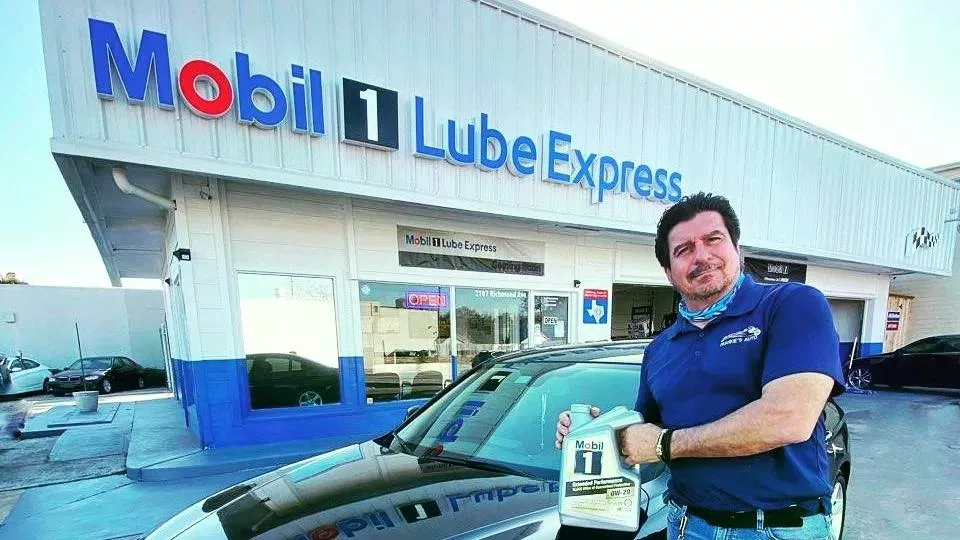 Frank Markantonis holding a jug of Mobil 1 outside his shop