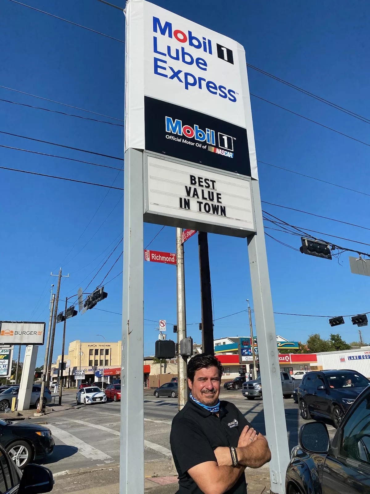 Frank Markantonis standing beneath the Mobil 1 Lube Express pole sign at Richmond and Shepherd